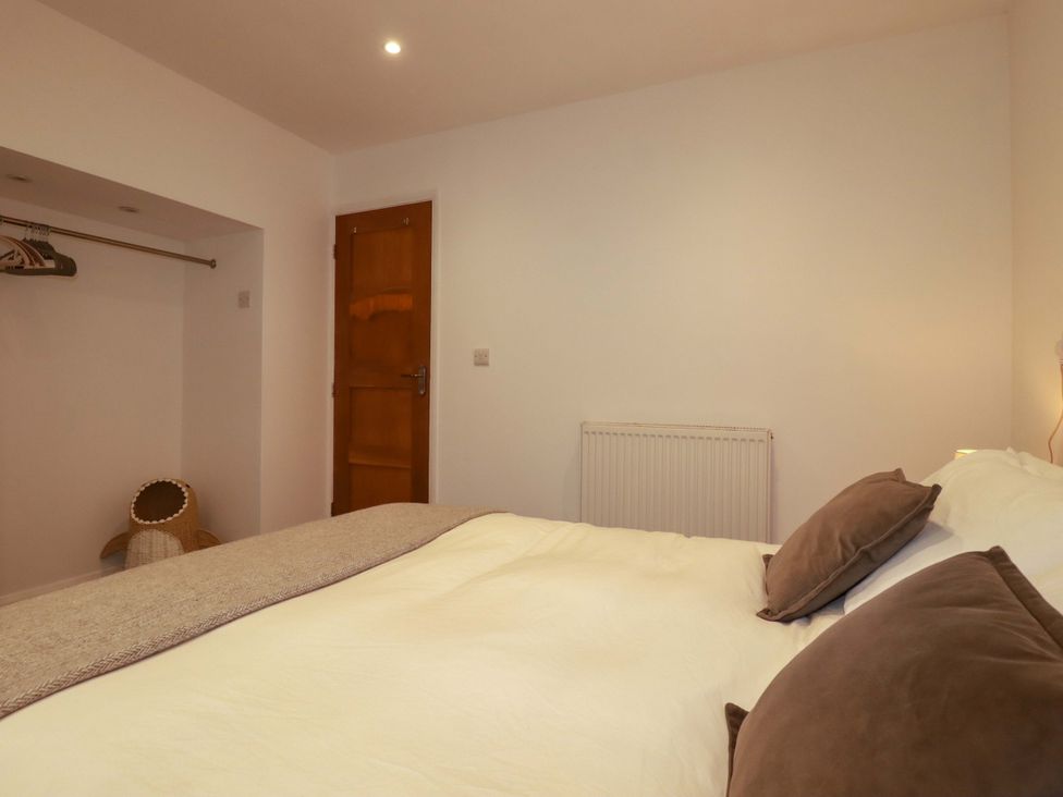 A bedroom with a bed and wardrobe space at The Maisonette in Hayle