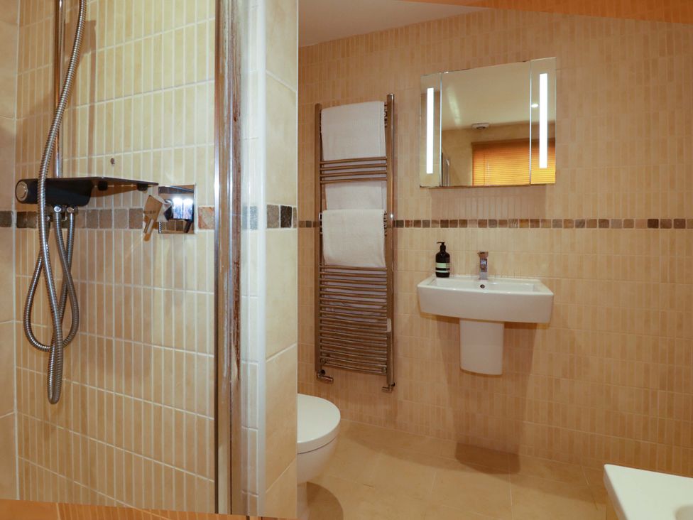 A bathroom with a shower, sink, and toilet at The Maisonette in Hayle