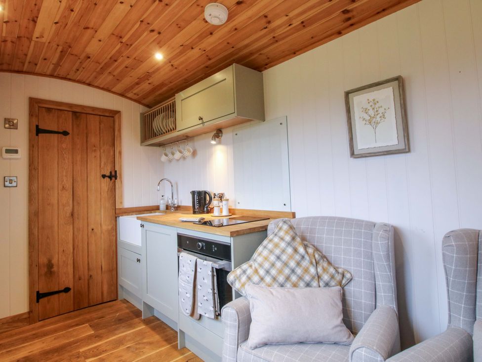 A kitchen with wooden door and table at Dave’s Place in Broadstone near Munslow