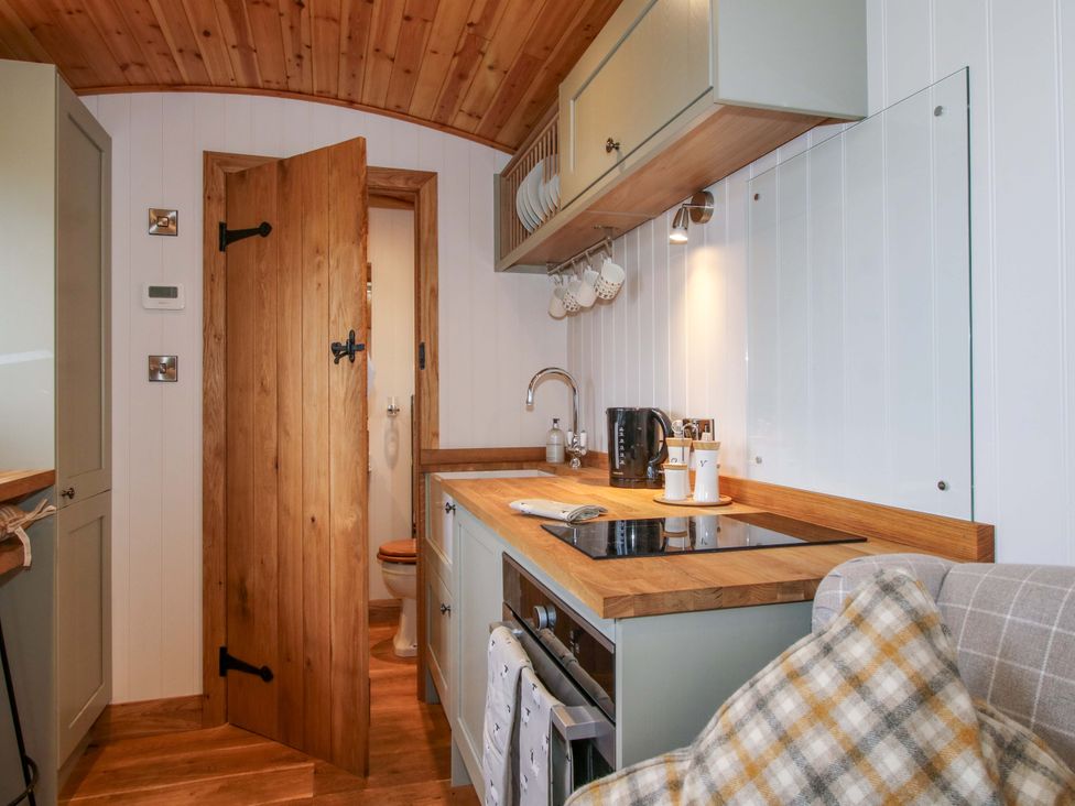 A kitchen with wooden countertops and kitchen sink at Dave’s Place Broadstone near Munslow