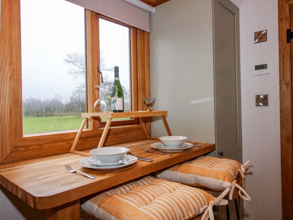 A dining area with a table and stools at Dave’s Place in Broadstone near Munslow