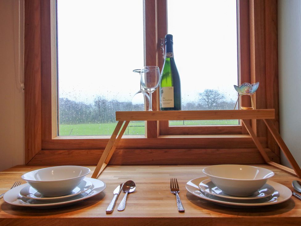 A kitchen window with plates and champagne at Dave’s Place Broadstone near Munslow