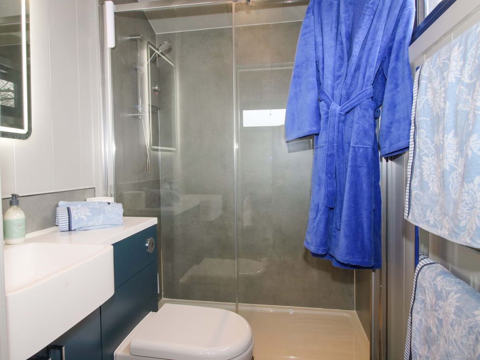 A bathroom with a shower and sink at Leafy Oak Lodge in Munslow