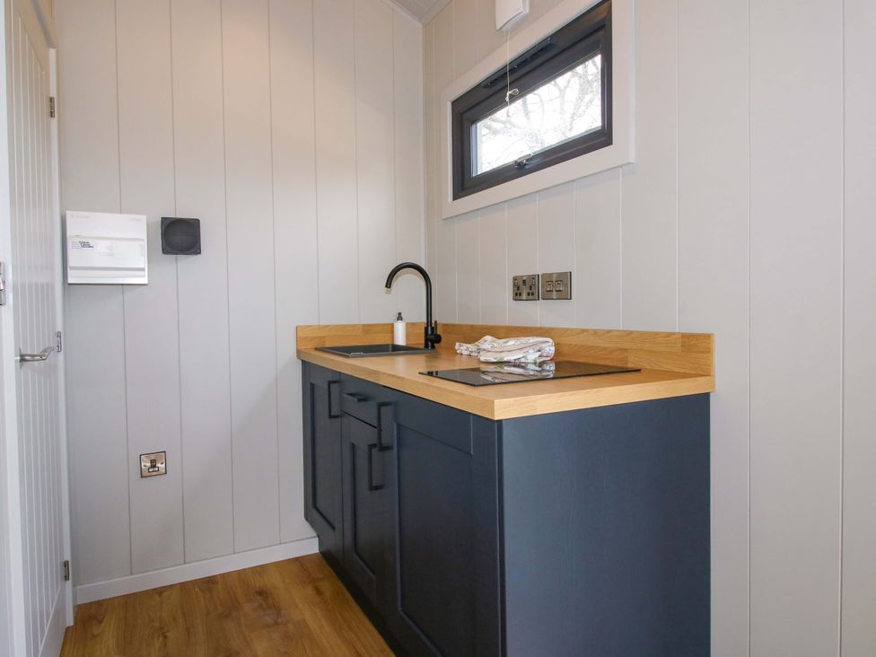 A kitchen with a sink and countertop at Leafy Oak Lodge in Munslow
