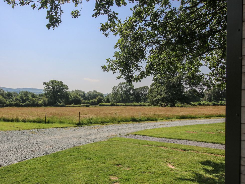 A view of an open field with trees at Leafy Oaks Cabin in Munslow