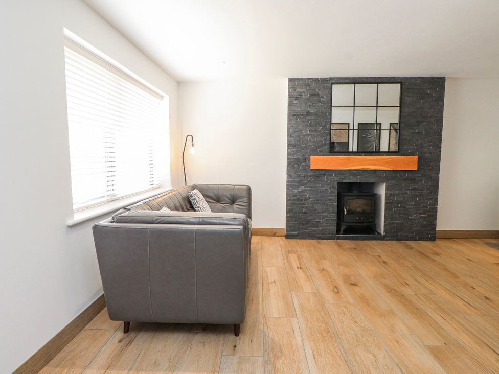 A living room with a sofa and fireplace at Bigting in Rhosneigr