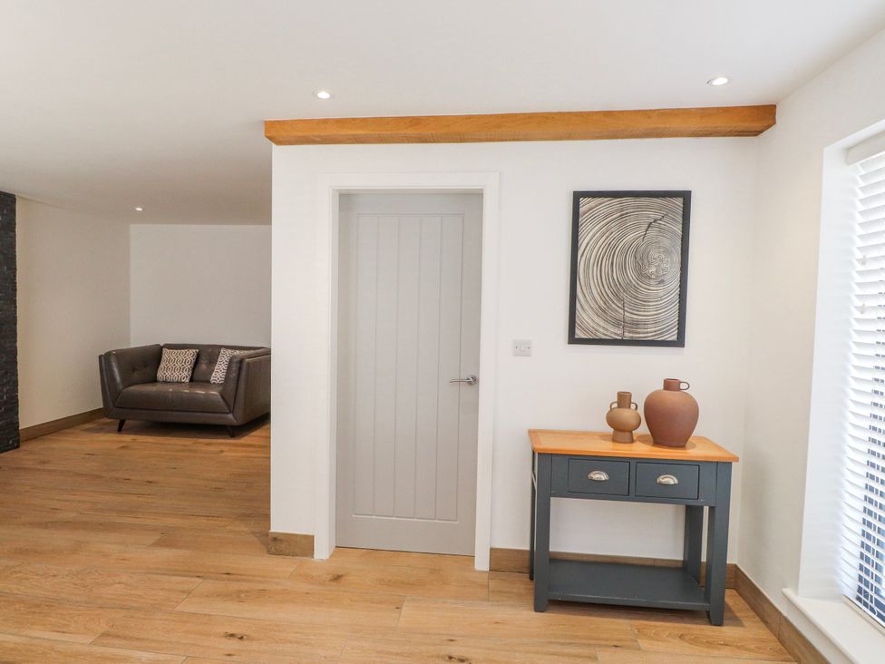 A living room with a sofa and console table at Bigting in Rhosneigr