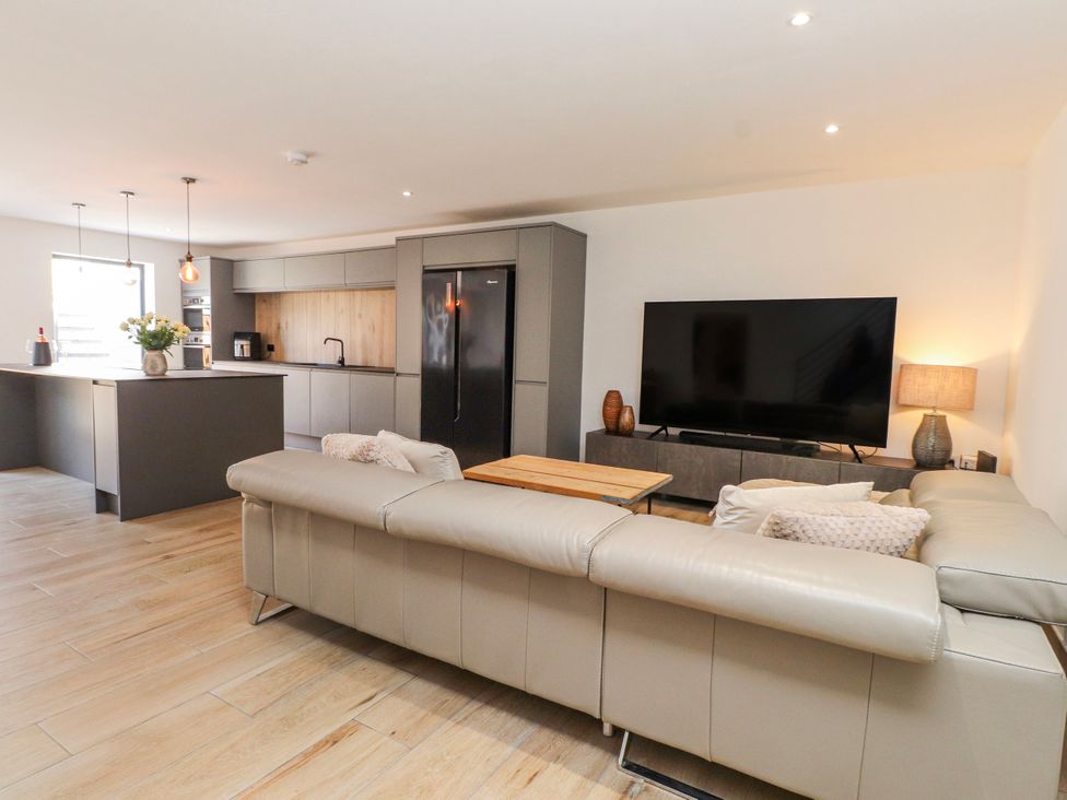 A living room with a sofa and television at Bigting in Rhosneigr