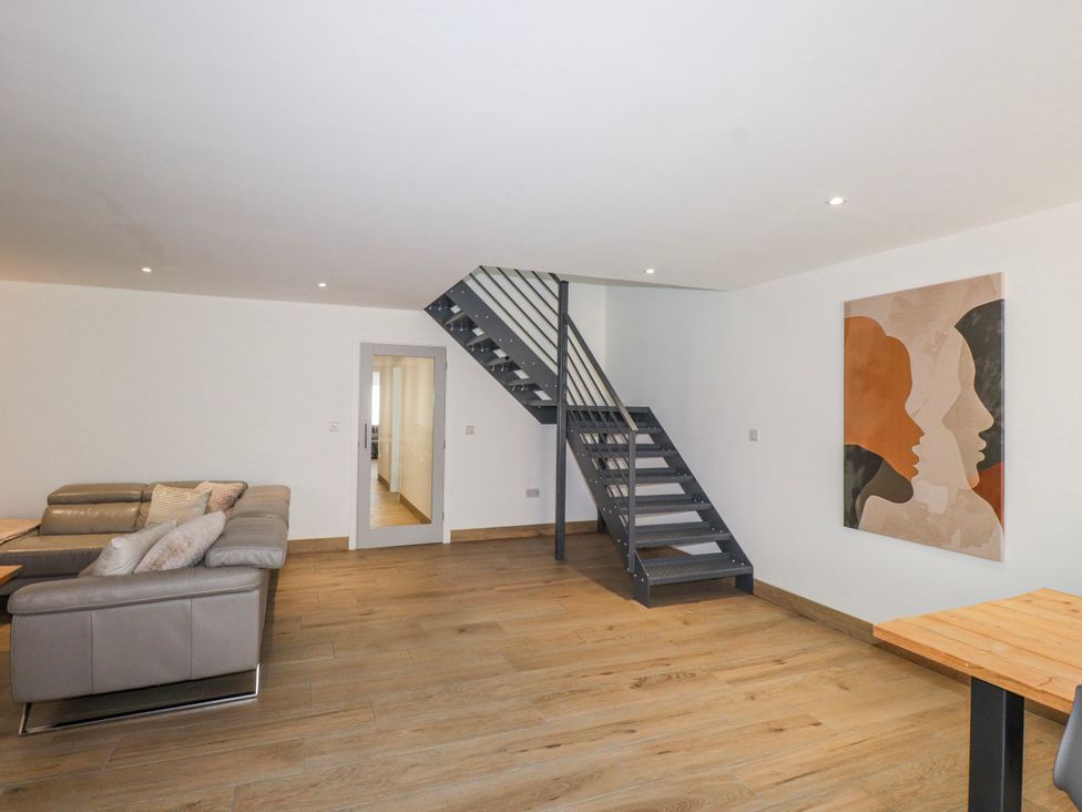 A living room with a staircase and wall art at Bigting in Rhosneigr