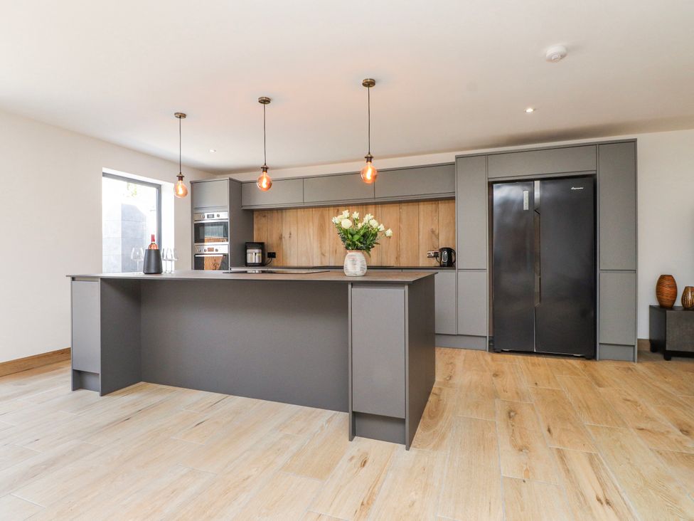 A kitchen with an island and modern appliances at Bigting in Rhosneigr