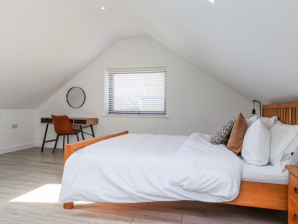A bedroom with a bed and desk at Bigting in Rhosneigr