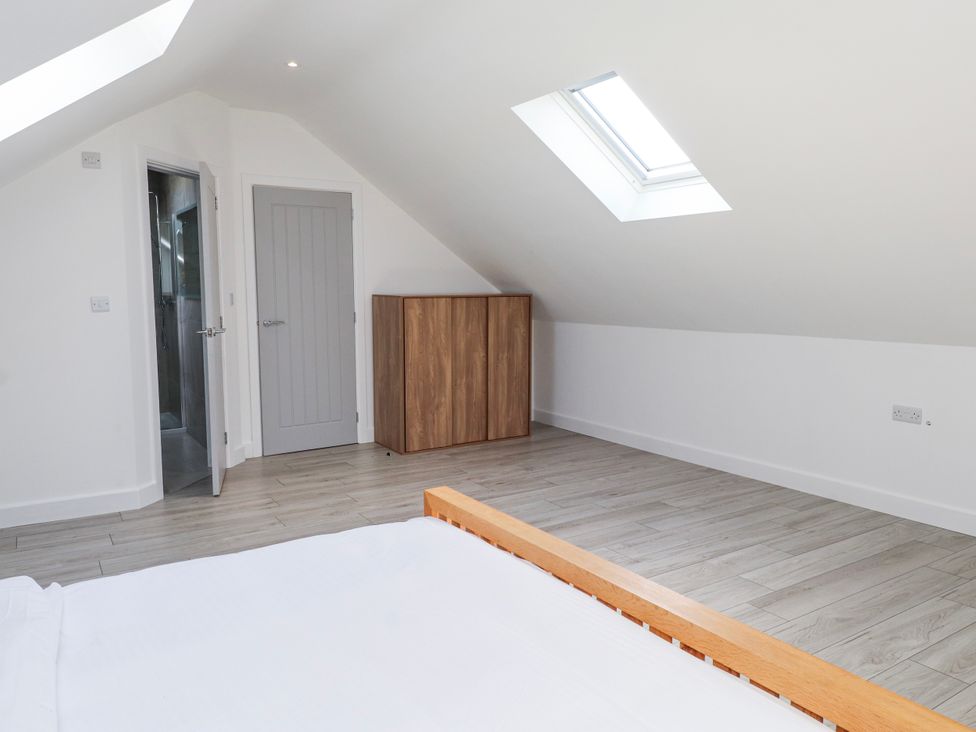 A bedroom with a bed and wardrobe at Bigting in Rhosneigr