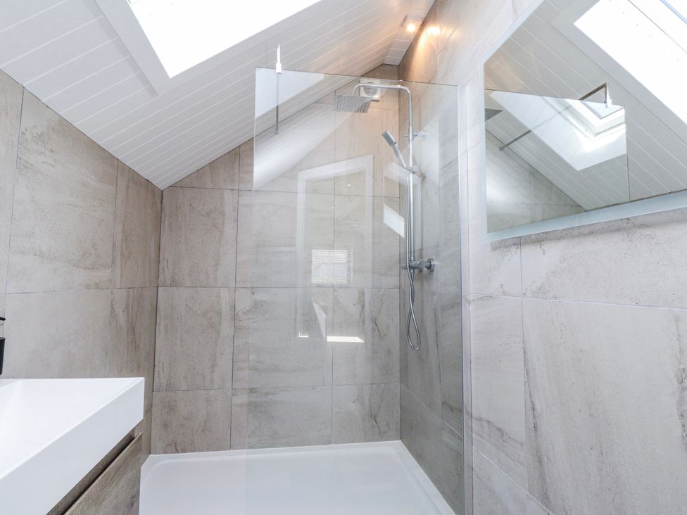 A bathroom with a shower and sink at Bigting in Rhosneigr