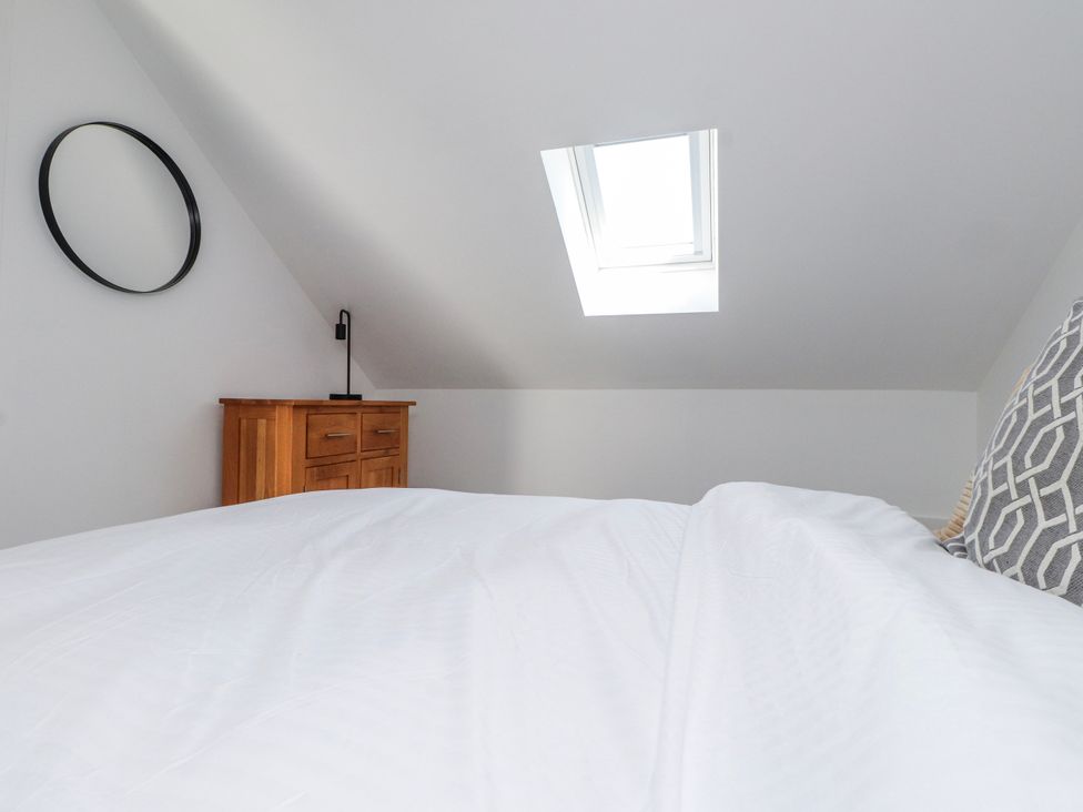 A bedroom with a bed and dresser at Bigting in Rhosneigr