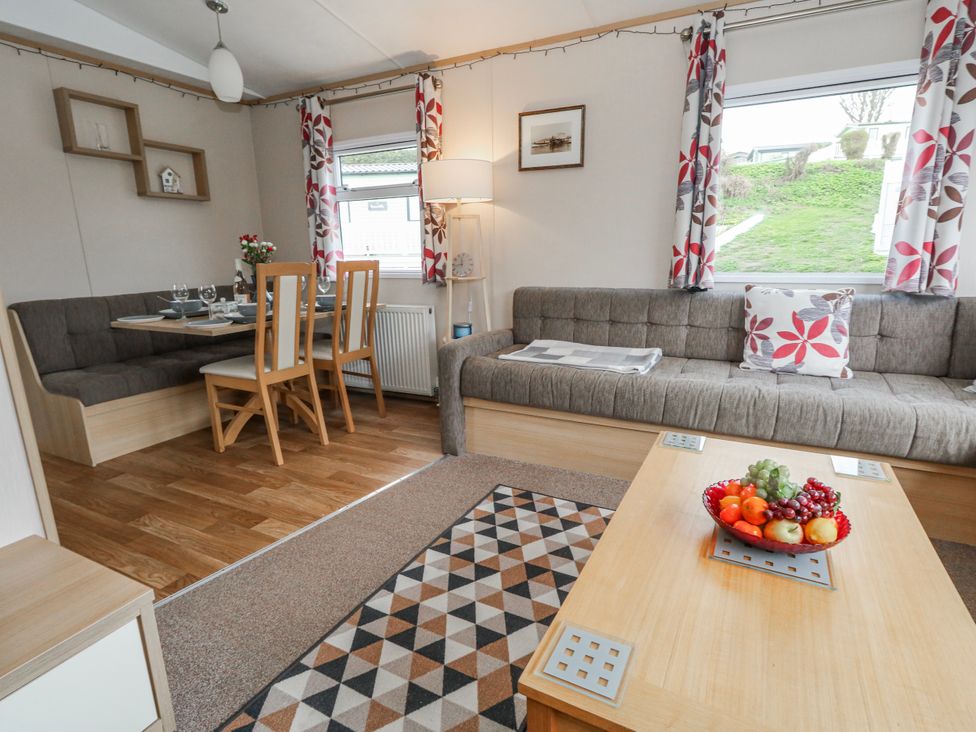 A living room with a dining area and sofa at Swanage Coastal Park Caravan in Swanage