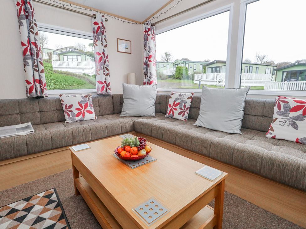 A living room with a sofa and coffee table at Swanage Coastal Park Caravan in Swanage