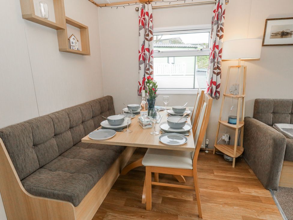 A dining room with a table set for meals at Swanage Coastal Park Caravan in Swanage