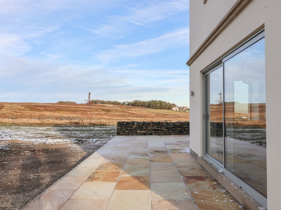 An outdoor area with a stone patio and a view of the landscape at Daisy Mount in Keighley