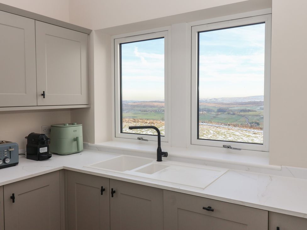 A kitchen with a sink and appliances at Daisy Mount in Keighley