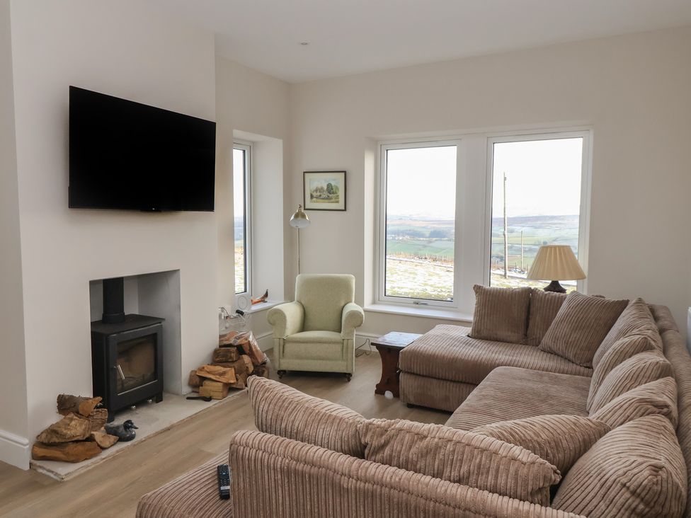 A living room with a sofa and television at Daisy Mount in Keighley