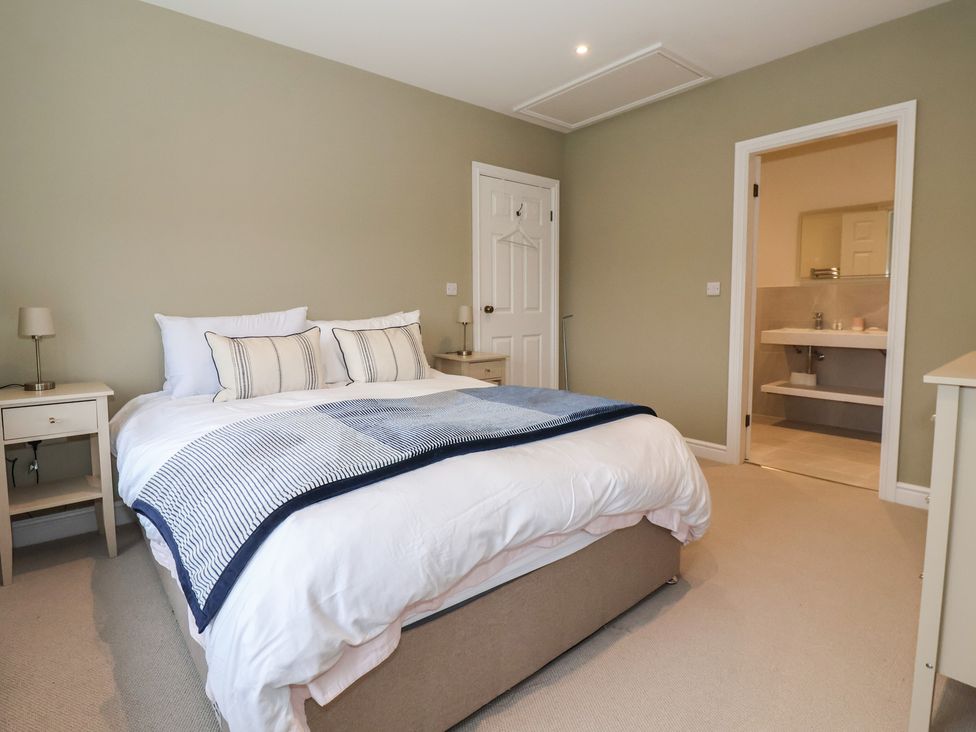 A bedroom with a bed and door leading to a bathroom at Daisy Mount Keighley