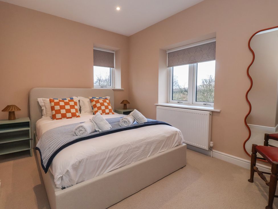 A bedroom with a bed and two windows at Daisy Mount in Keighley