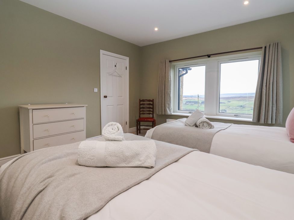 A bedroom with two beds and a window at Daisy Mount in Keighley