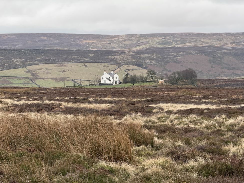A house in a field surrounded by hills at Daisy Mount in Keighley