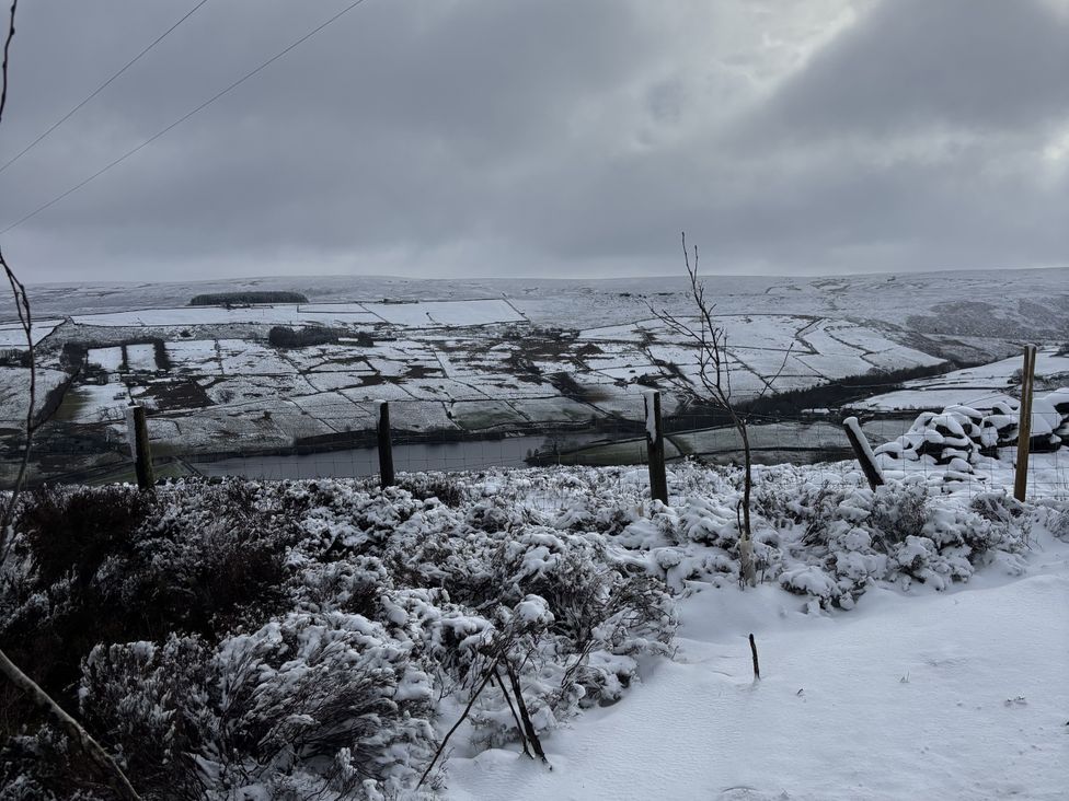 A snowy landscape with a river and hills at Daisy Mount in Keighley