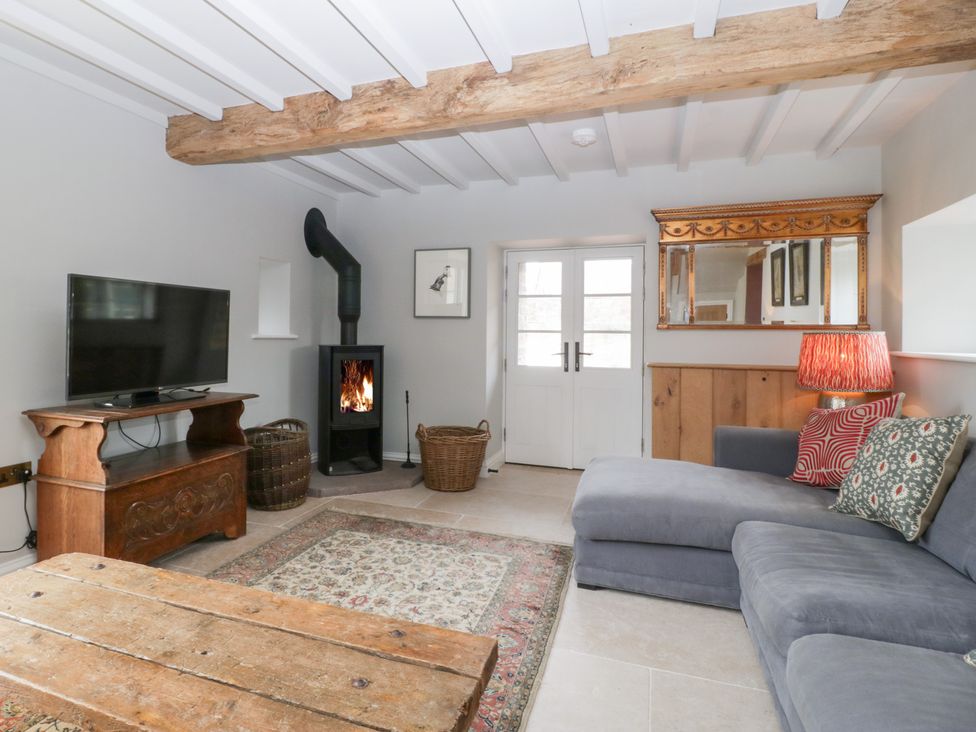 A living room with a television and a sofa at Velindra Farm Cottage in Hereford
