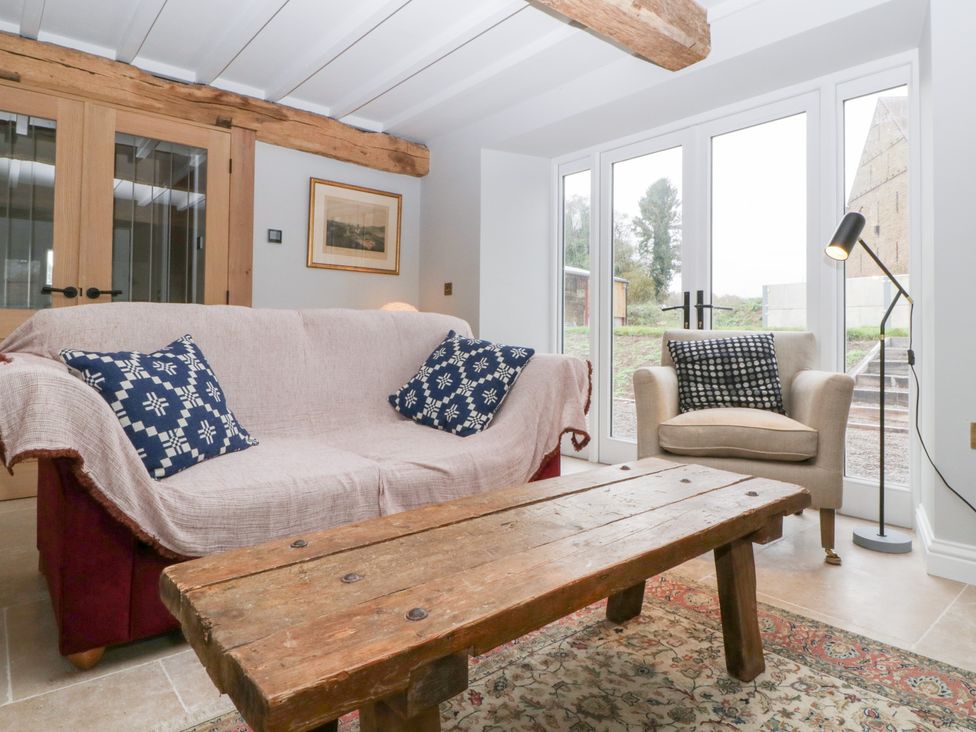 A snug with a sofa and armchair at Velindra Farm Cottage Hereford