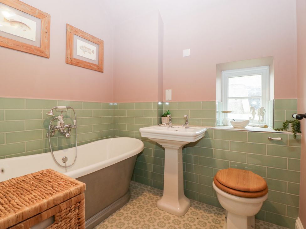 A bathroom with a bathtub, sink, and toilet at Velindra Farm Cottage Hereford