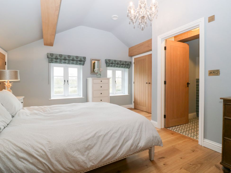 A bedroom with a bed and chest of drawers at Velindra Farm Cottage Hereford