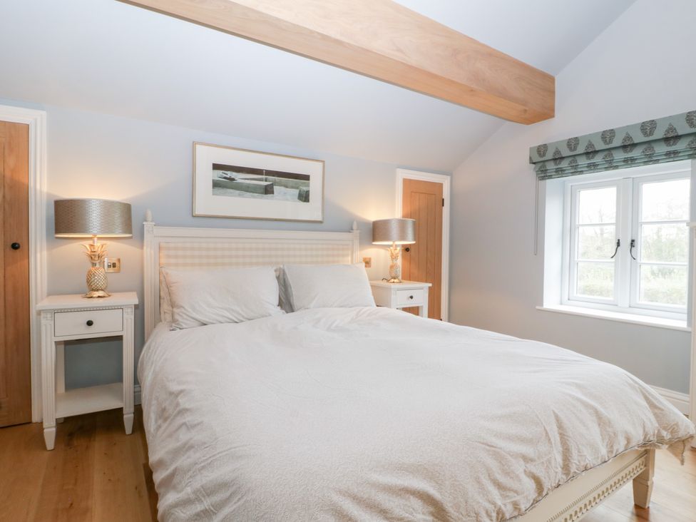 A bedroom with a bed and lamps at Velindra Farm Cottage Hereford