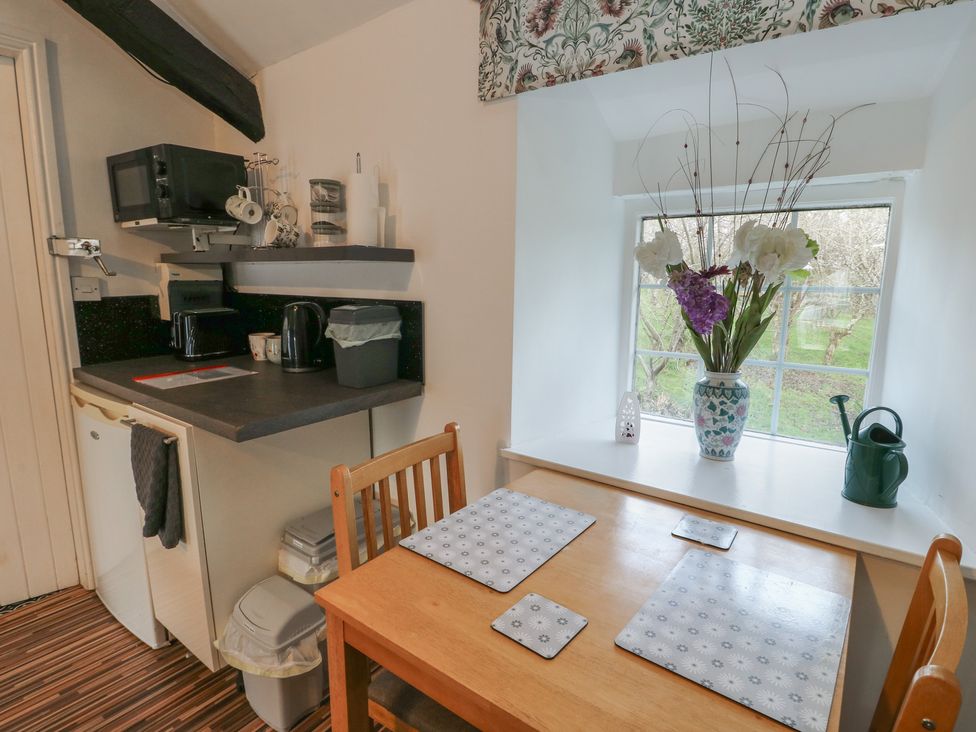 A kitchen with table and chairs at Fullers Studio in Caergeiliog