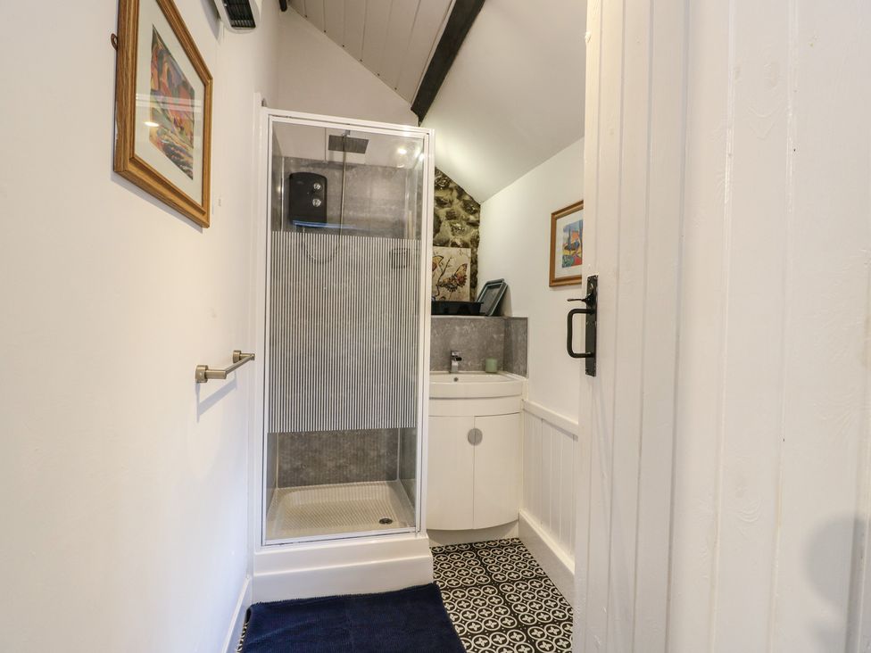 A bathroom with a shower and sink at Fullers Studio Caergeiliog