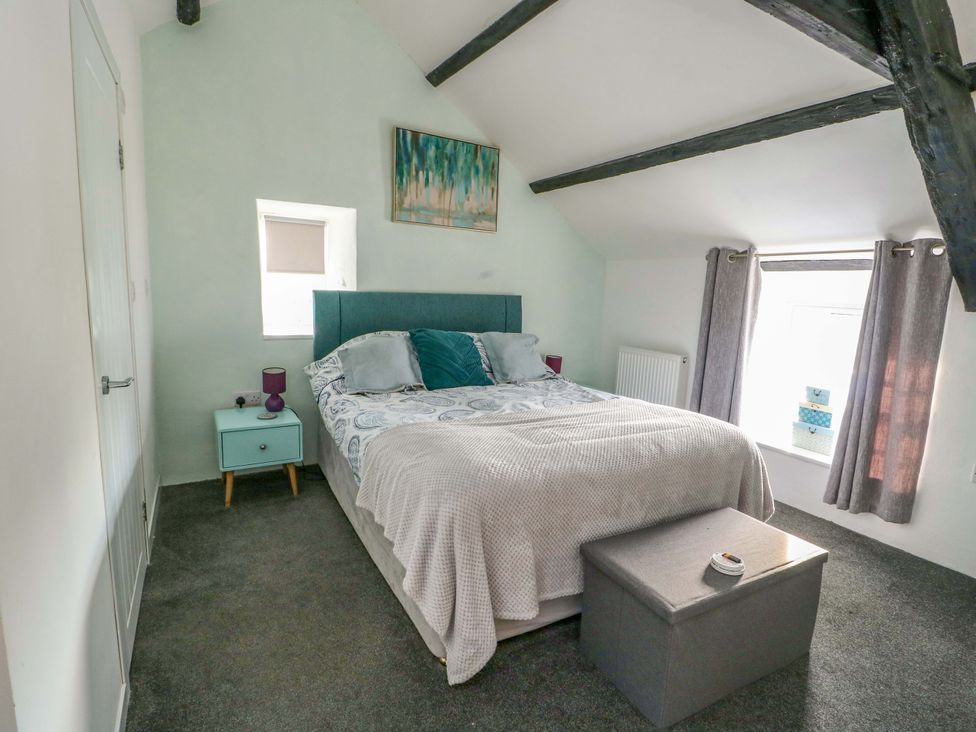 A bedroom with a bed and side table at The Mill in Holyhead