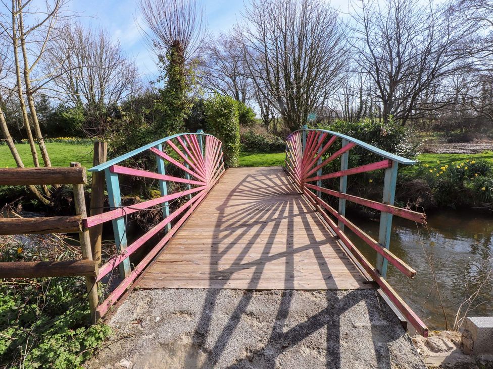 A bridge with wooden planks and decorative railings at The Mill in Caergeiliog
