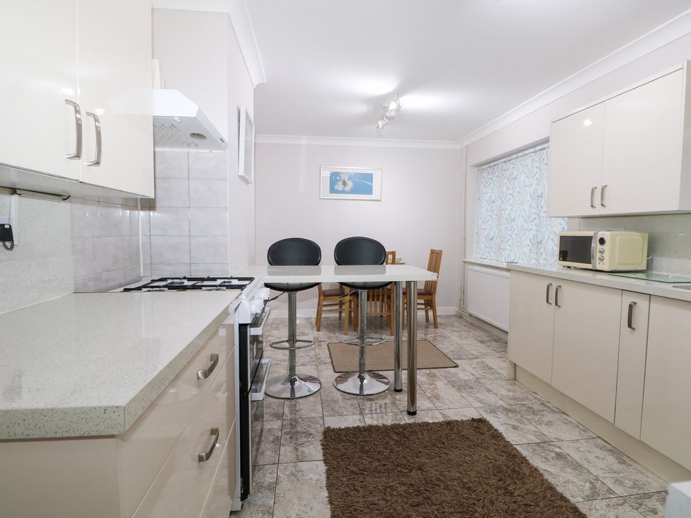 A kitchen with a gas stove and dining area at 24 Dunkirk Close Romney Marsh
