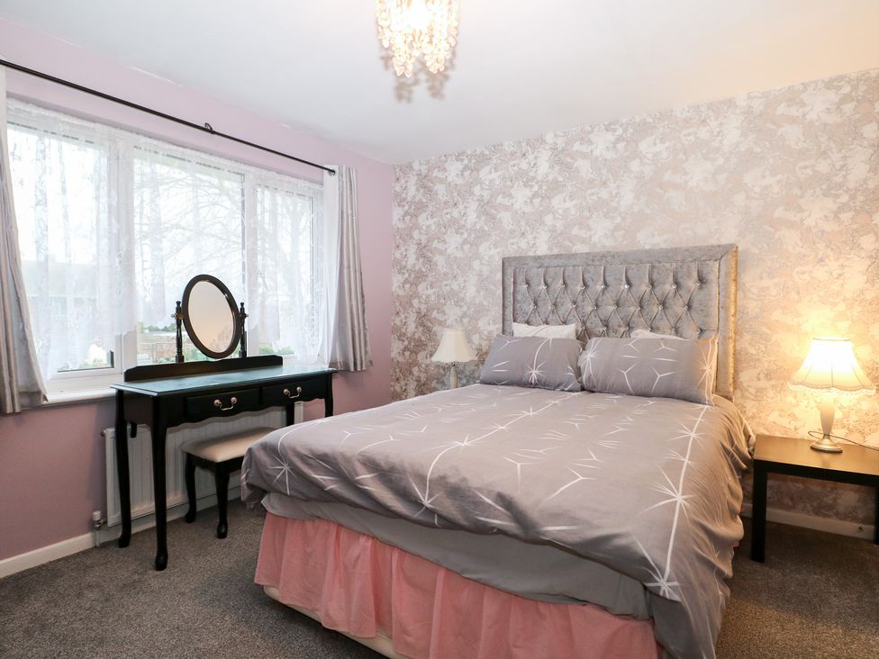A bedroom with a bed and dressing table at 24 Dunkirk Close in Romney Marsh