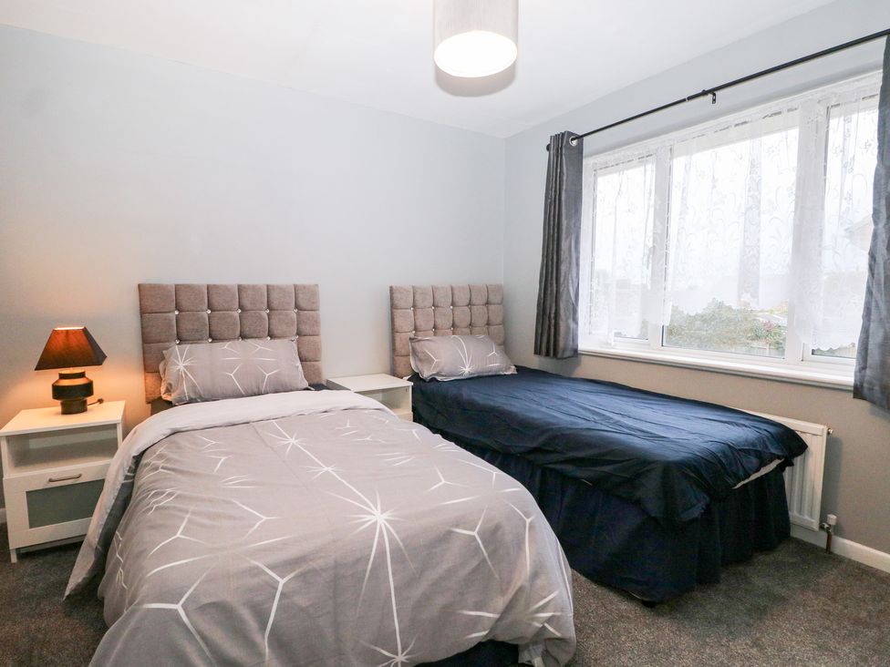 A bedroom with two beds and a nightstand at 24 Dunkirk Close in Romney Marsh