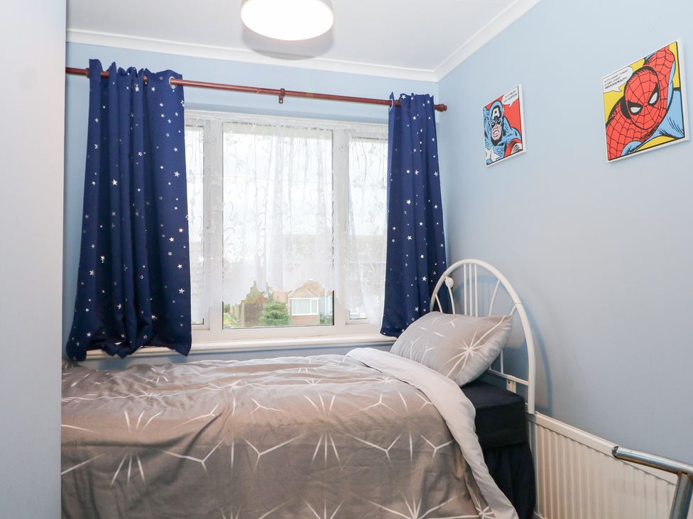 A bedroom with a bed and curtains at 24 Dunkirk Close Romney Marsh