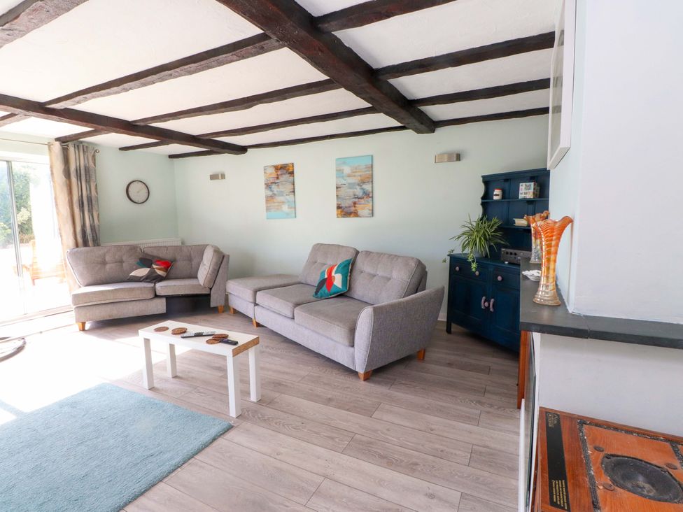 A living room with a sofa and a coffee table at Ty Crigyll in Caergeiliog