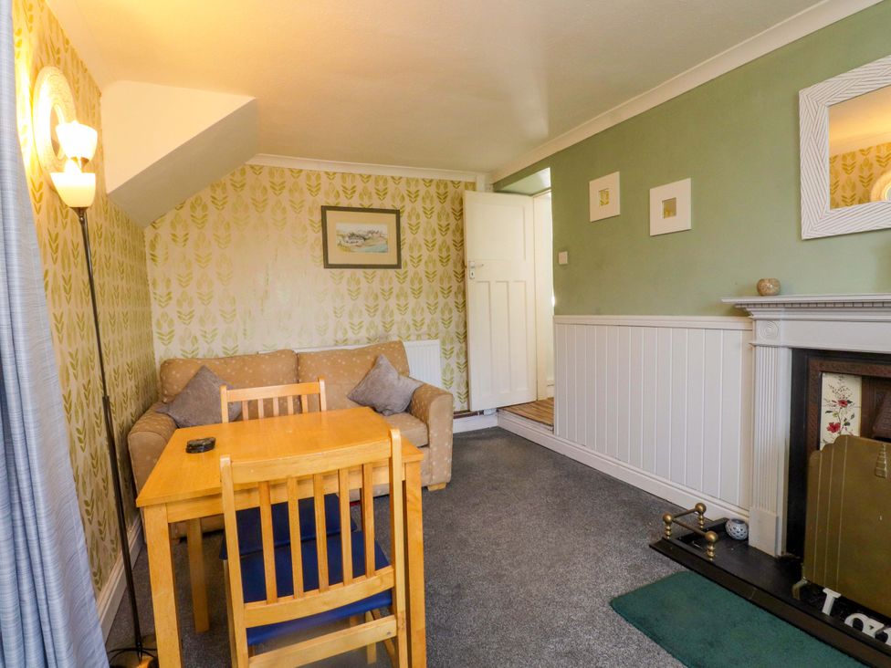 A living room with a sofa and dining table at Ty Crigyll in Caergeiliog