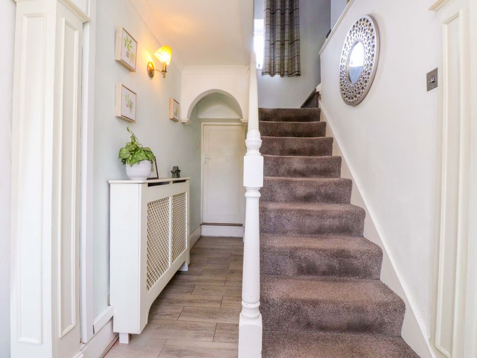 A hallway with a staircase and a plant at Ty Crigyll in Caergeiliog
