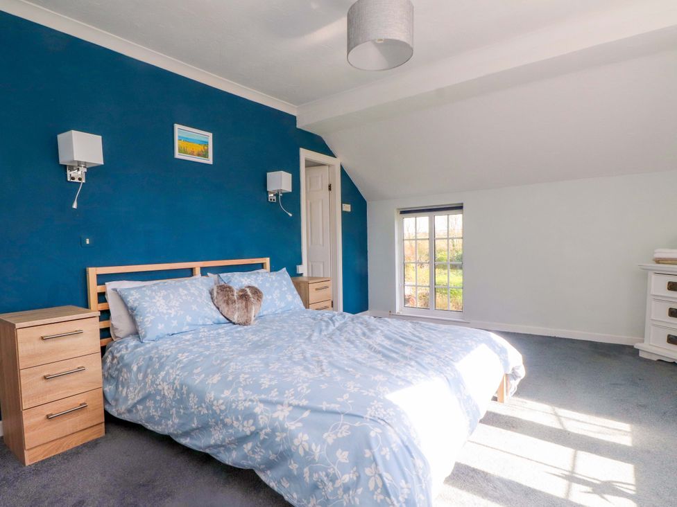 A bedroom with a bed and bedside tables at Ty Crigyll in Caergeiliog