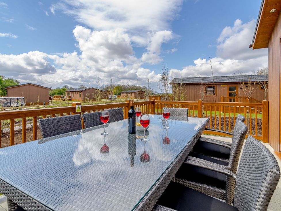 An outdoor seating area with a table and glasses at The Alwalton in Kings Cliffe