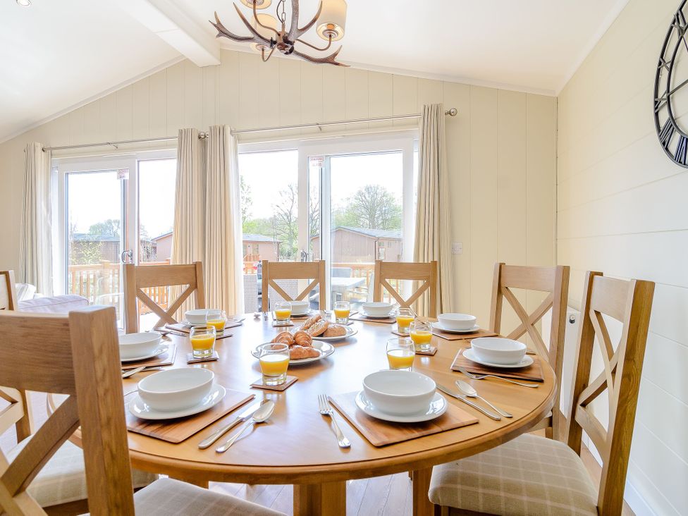 A dining room with a round table and plates at The Alwalton in Kings Cliffe
