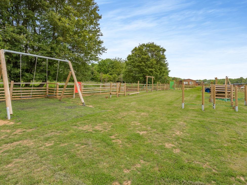 An outdoor area with swings and play equipment at The Alwalton in Kings Cliffe