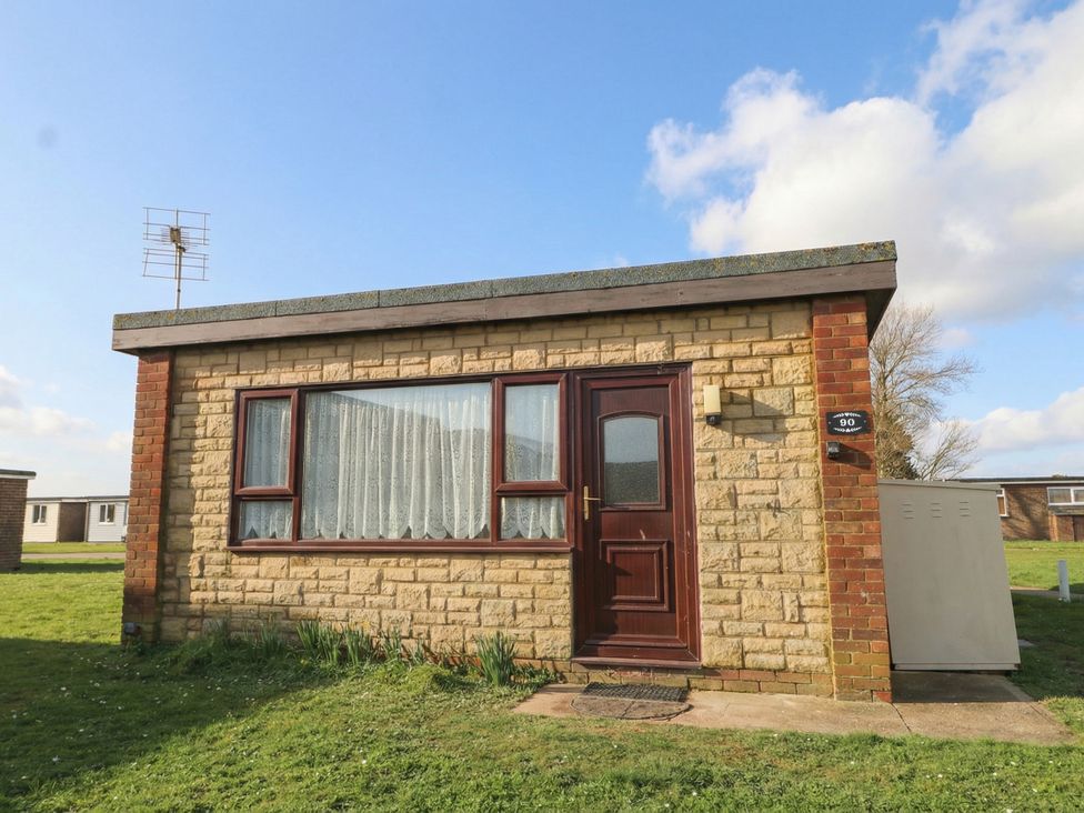 A house with a front door and window at 90 Bay View in New Romney